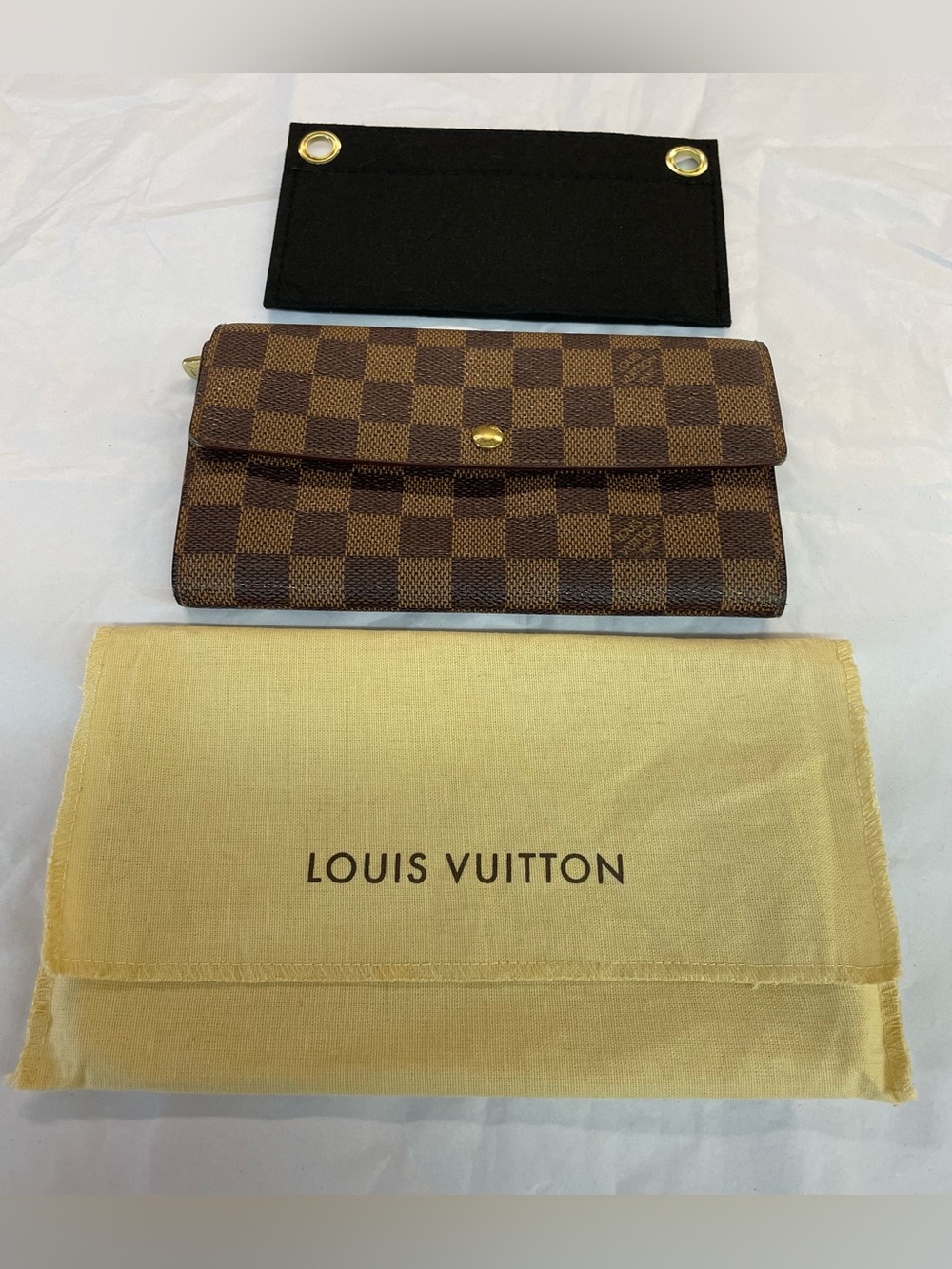 Louis Vuitton Sarah wallet in Damier Ebene canvas.